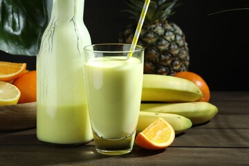 Superfood. Refreshing smoothie in bottle, glass and ingredients on wooden table against black...