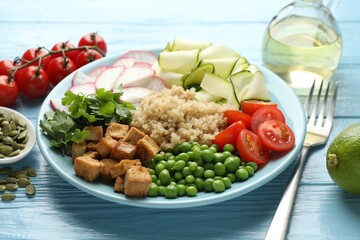 Different healthy vegetarian food served on light blue wooden table, closeup