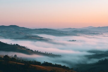 Fototapeta premium Cinematic mist rolls over layered hills at sunrise, casting a dreamy and ethereal mood across the landscape.