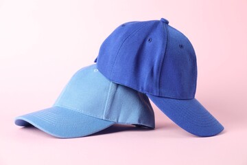 Blue baseball caps on pink background, closeup. Mockup for design