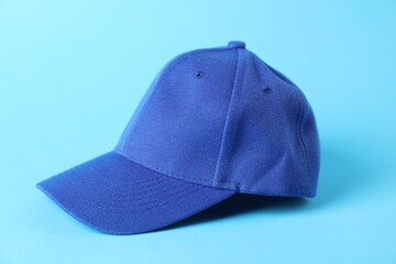 One stylish baseball cap on light blue background, closeup. Mockup for design