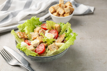 Delicious salad with croutons, chicken, quail eggs, tomato and cheese on grey table, closeup