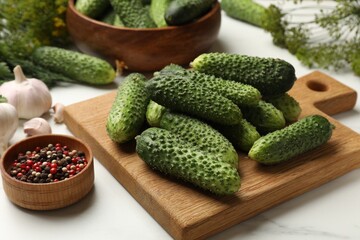 Making pickles. Fresh cucumbers, peppercorns and garlic on white table, closeup