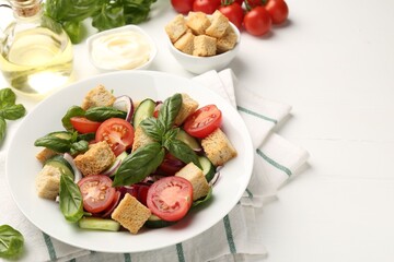 Delicious salad with croutons and ingredients on white wooden table, closeup