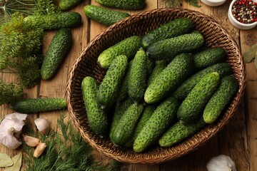 Making pickles. Fresh cucumbers and other ingredients on wooden table, flat lay