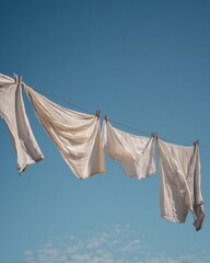 Linen clothes flutter softly on an outdoor line in the breeze, capturing simplicity, freshness, and everyday beauty.