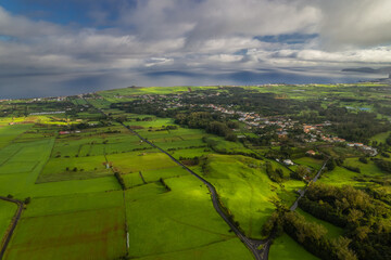 Scenic volcanic landscape of the Azores with lush green hills, dramatic coastline, and crater lakes...