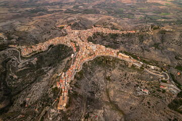 Aerial view of Centuripe, Sicily – a historic hilltop town shaped like a star, surrounded by rolling hills and with Mount Etna visible in the distance.