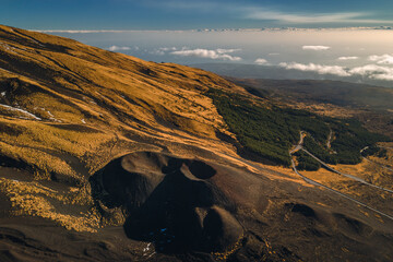Volcanic landscape of Mount Etna with rugged lava fields, smoke rising from the crater, and...