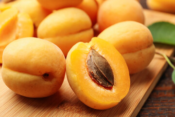 Yummy ripe apricots on wooden board, closeup