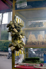A traditional Sate Padang seller's cart displaying hanging ketupat and skewers, ready for an authentic Indonesian street food experience.