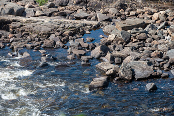 streams of clear waterfall water and stone banks of a mountain river