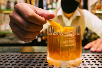 Bartender Garnishing an Old Fashioned with Orange Peel