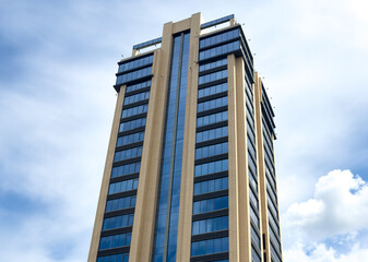 A tall building with a lot of windows and a blue sky in the background