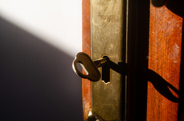 Unlock new possibilities with this vintage key in lock, casting shadows in a warm light to inspire...