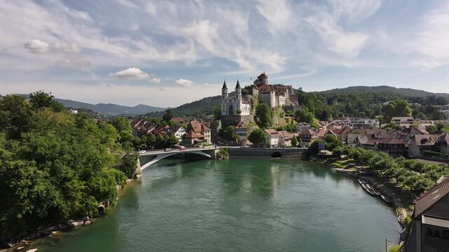 Drone aerial view of historic Aarburg castle perched on rock spur, winding Aare river with Aarewaage whirlpool basin and leafy valley in Solothurn canton.