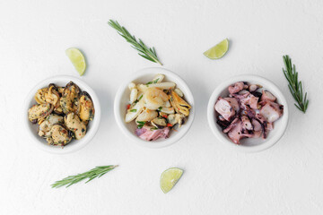 Three seafood bowls with herbs and lime on white background for minimal food composition or diet...