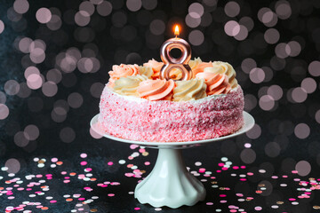 Colorful birthday cake with pink frosting and a candle on top