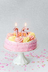 Pink birthday cake decorated with candles for a sweet sixteen celebration