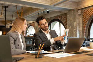 Colleagues working together in the office and discussing the project details