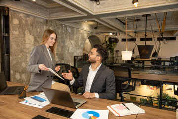 Colleagues working together in the office and discussing the project details