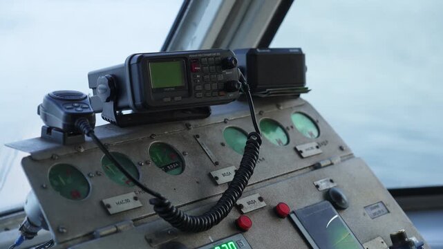 Captain using ship radio controls on bridge. Clip