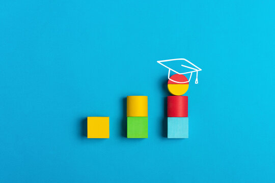 Graduation and education concept with colorful blocks and academic cap on a blue background. Symbol of learning, growth, and academic achievement
