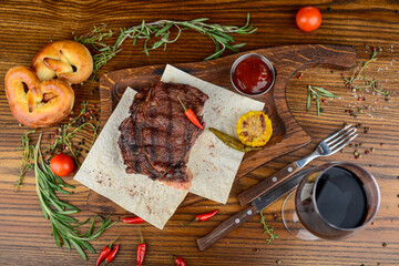 huge steak grilled on parchment on a wooden board with a twist