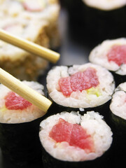 Fresh tuna sushi rolls with chopsticks on a dark background, Japanese cuisine