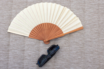 Hand Fan and Sunglasses on Outdoor Cushion