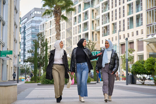 Three muslim women walking and talking in the city