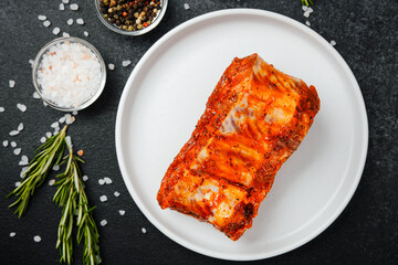 Marinated pork ribs on white plate with herbs and spices