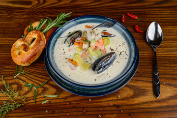 creamy seafood soup in a blue plate on a decorative background