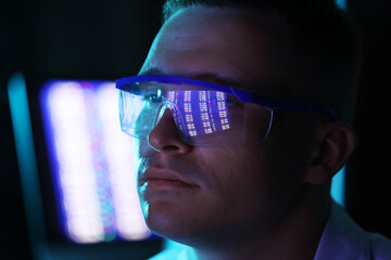 Young man wearing glasses with reflection on blurred background, closeup