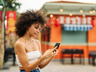 Portrait of a young black woman girl talking discussing on smart phone, answeing the phone, having fun and sitting on a scooter motorcycle