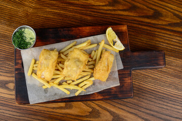 fried rolls with french fries on a wooden board on a background