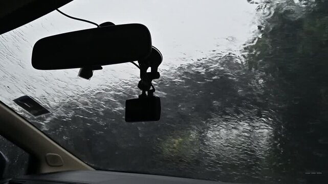 Heavy rain drop on the car glass window during raining.