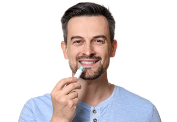 Smiling man applying lip balm onto his lips on white background