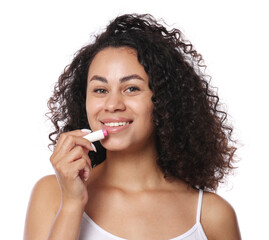 Smiling woman applying lip balm onto her lips on white background