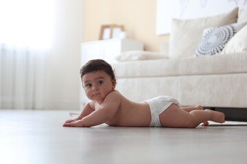 Cute little baby crawling on floor at home