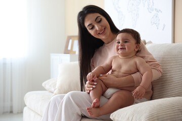 Happy mother with her cute little baby at home, space for text