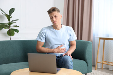 Sick man having online consultation with doctor via laptop at home