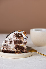 Piece of Pancho cake with pineapple, vegan sour cream, chocolate biscuit and walnut and cup of chicory drink. Sugar, lactose and gluten free. Vertical orientation.