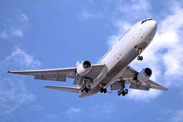 Passenger airplane taking off under cloudy blue sky