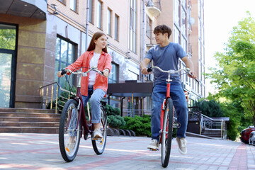 Obraz premium Teenage girl and boy riding bicycles on city street