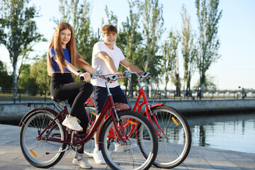 Fototapeta premium Teenage girl and boy riding bicycles on city street
