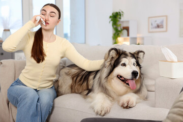 Woman suffering from allergy with her dog at home