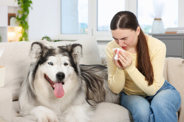 Woman suffering from allergy with her dog at home