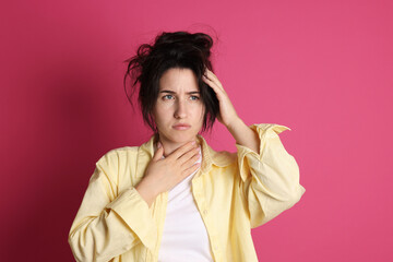 Woman suffering from hangover on crimson background