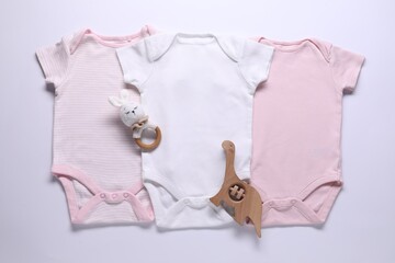 Baby onesies and accessories on white background, flat lay